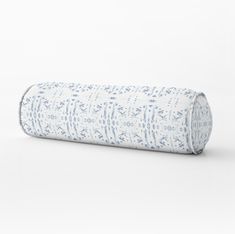 a rolled up blue and white pillow on a white background