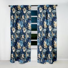 a blue floral curtain hanging in front of a window