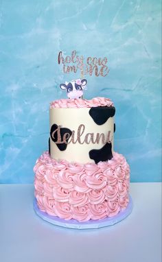 a pink and white cake with a cow on top