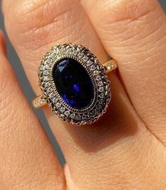 Vintage Edwardian Ring, Halo Wedding Ring, Blue Sapphire Oval Engagement Ring, Bezel Set Milgrain Ring, Filigree Ring, Round Diamond Ring Item Description: Main Stone - Simulant Diamond Main Stone Shape - Oval Cut Side Stone - Simulant Diamond Side Stone Shape - Round cut 1. White Gold: 10K/14K/18K 2. Yellow Gold: 10K/14K/18K 3. Rose Gold: 10K/14K/18K 4. Silver: Sterling Silver 925 Size Customization: What Size you want... * You can also Customize ring size in US 4 to US 12! It sometimes affects to price. * Main Stone & Shape Customization: Main Stone: Cubic Zirconia, Moissanite, Natural Diamond, CVD Diamond Shape Choice: Round Cut, Heart, Princess Cut, Pear Cut, Cushion Cut, Marquise, Oval Shape, Asscher, Emerald, Radiant, Old European Cut, Old Mine Cut * Check out Special Notes: At check Blue Emerald Cut Ring With Bezel Setting, Blue Emerald Cut Rings With Bezel Setting, Oval Cabochon Sapphire Ring With Bezel Setting For Anniversary, Oval Cabochon Bezel Set Sapphire Ring For Anniversary, Anniversary Oval Cabochon Sapphire Ring With Bezel Setting, Oval Sapphire Diamond Ring With Bezel Setting, Sapphire Cluster Ring With Halo Design For Wedding, Anniversary Sapphire Ring With Bezel Setting, Heirloom Style Sapphire Ring With Halo Design