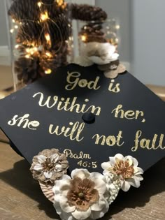 a graduation cap decorated with flowers and the words god is within her she will not fall