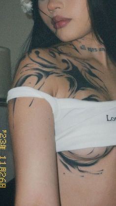 a woman with tattoos on her chest and arm