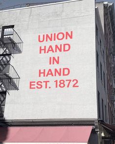 a large sign on the side of a building reads union hand in hand est 1876