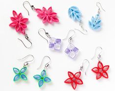 six different colored flower shaped earrings on white background with text that reads made with paper