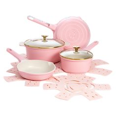 pink kitchenware set with gold trimmings on the top and bottom, including pots and pans