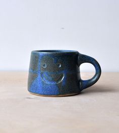 a blue and black cup sitting on top of a wooden table