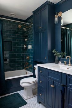 a bathroom with blue cabinets and white toilet