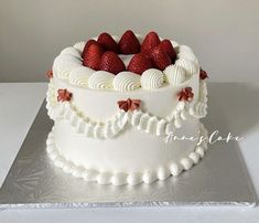 a cake with white frosting and strawberries on top