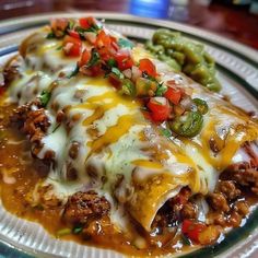 an enchilada on a plate with green beans and peppers