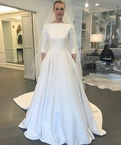 a woman in a white wedding dress standing next to a mannequin wearing a tiara