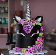 a cake decorated with flowers and a unicorn's head