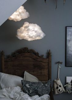 there is a bed with two clouds above it