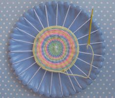 a blue paper plate with a circular design on the rim and string attached to it