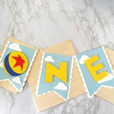 a wooden sign with the letter n e painted on it