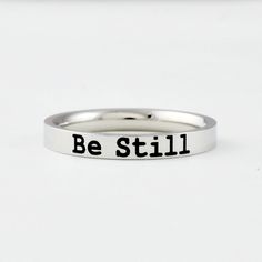 "This listing is for one stainless steel band ring, engraved with \"Be Still\" on the outside.  It makes a best gift for friends, sisters in Christ or yourself.  Materials & Features: This ring is made of high quality hand polished solid stainless steel, which is hypoallergenic (good for metal-sensitive skin). Stainless steel will not tarnish, its luster and durability will make it last for many years. The black text on the ring will not fade out over time. Sizes: This ring is 3 mm wide, dainty Sisters Best Friends, Sorority Sisters, Stacking Bands, Wide Ring, Fade Out, Wide Rings, Religious Quotes, Stainless Steel Band, Inspirational Gifts