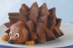 a chocolate hedgehog sitting on top of a white plate next to blue streamers