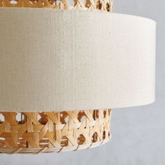 a woven lamp shade hanging from a ceiling fixture