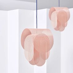 two pink lamps hanging from the ceiling in a room with white walls and flooring