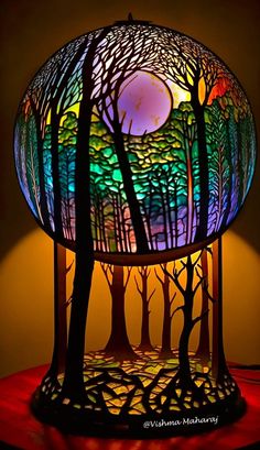 a lamp that is sitting on top of a table with trees and moon in the background