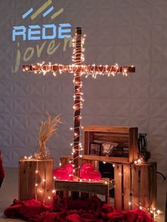 a wooden cross sitting on top of a table next to boxes filled with red hearts