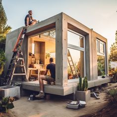 two men are sitting on the roof of a tiny house that is built into the ground