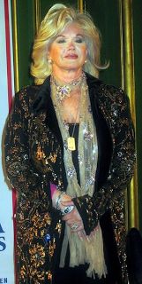 a woman with blonde hair wearing a black jacket and gold sequins