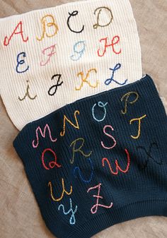 two sweaters with letters on them laying next to each other