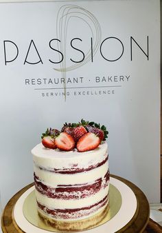 a cake sitting on top of a wooden table next to a sign that says passion restaurant and bakery