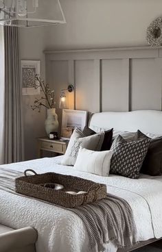 a bed with white sheets and pillows in a bedroom