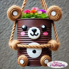 a bear planter hanging from a rope with flowers in it's mouth and eyes