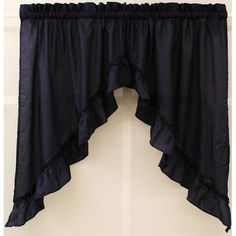 a black curtain with ruffles hanging from it's side in front of a white wall