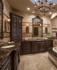 a luxurious bathroom with chandelier and marble counter tops