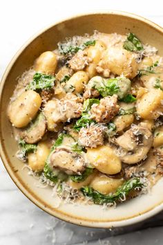 a close up of a bowl of food with broccoli and mushrooms in it