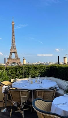 the eiffel tower is seen in the distance from an outdoor dining area with tables and chairs