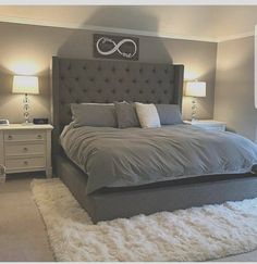 a large bed sitting in the middle of a bedroom next to two nightstands and lamps