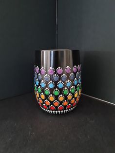 a colorful vase sitting on top of a counter next to a wall with black walls