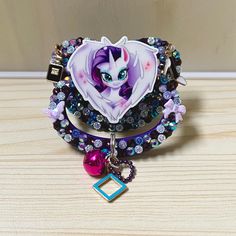 a bracelet with an image of a pony on it and a charm hanging from the clasp