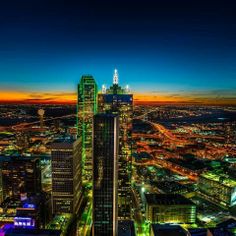 the city lights shine brightly at night in this aerial view from an observation point on top of a skyscraper