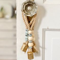 a close up of a door handle with beads and charms hanging from it's side