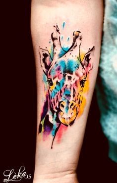 a colorful giraffe tattoo on the arm