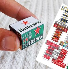 a person is holding a box of heineken in their left hand and the other one has a red star on it