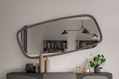 a large mirror sitting on top of a dresser next to a plant