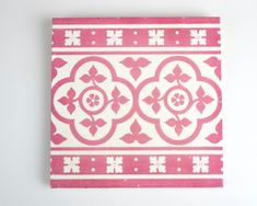 a pink and white tile with flowers on it