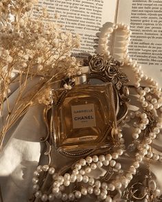 a bottle of chanel surrounded by pearls and flowers