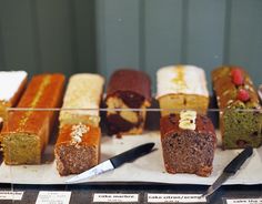 there are many different types of breads on the display case with each one cut in half