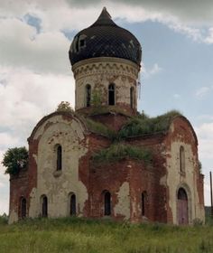 an old building with grass growing on the roof