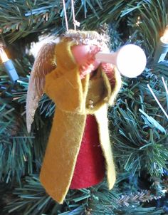 an angel ornament hanging from a christmas tree