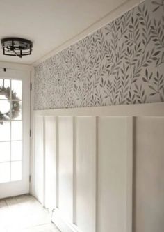 an empty room with a wreath on the door and wallpapered walls behind it