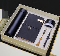 an open box containing a pen, notebook and other items