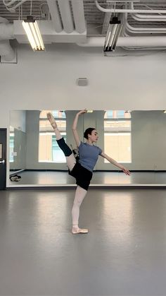 a ballerina is practicing her moves in an empty room